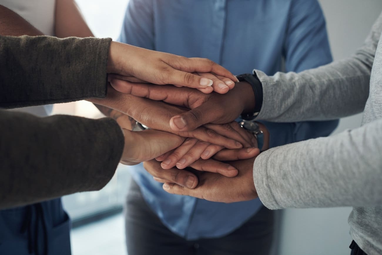 A group of people with their hands together.