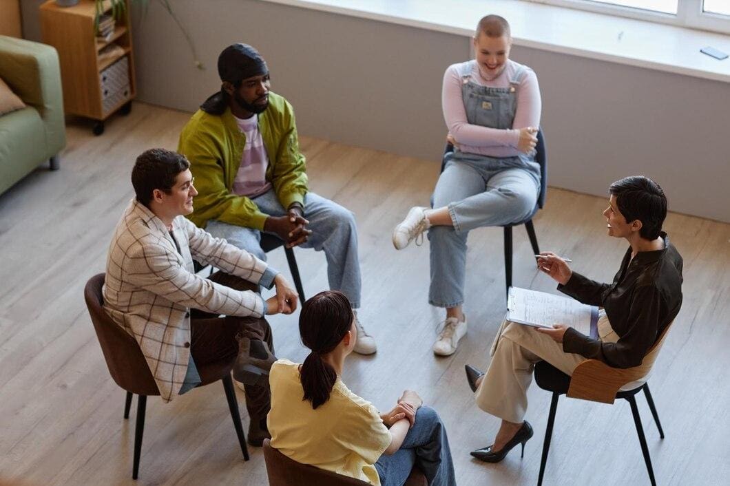 A group of people sitting in chairs on the floor