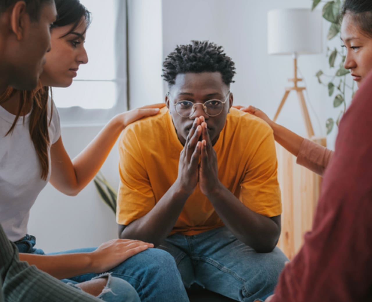 Young man distressed, friends offering support