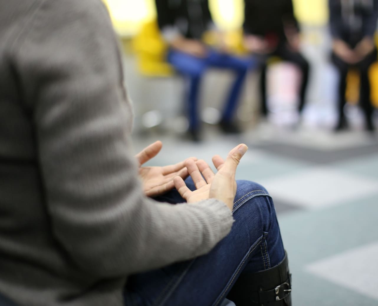 A person sitting on the ground with their hands in the air.